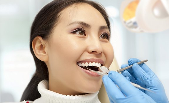 Woman smiling at her Rockwall dentist while getting a dental crown