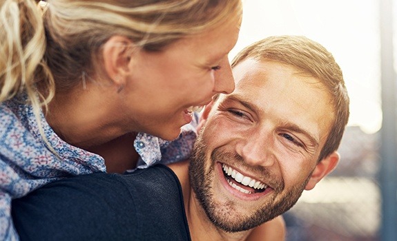 Smiling man and woman with natural looking dental crowns