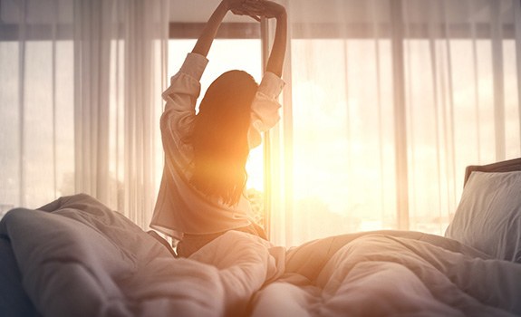 Woman stretching after night of restful sleep