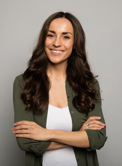 Portrait of smiling, confident woman against gray background