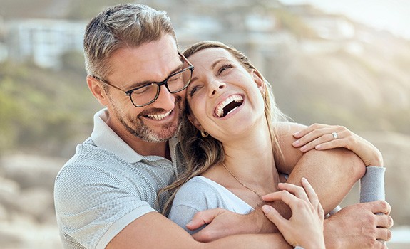 Happy, smiling couple embracing on the beach
