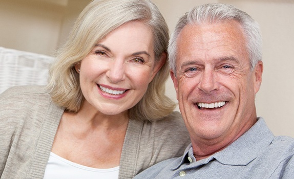 Senior couple sitting on couch and smiling
