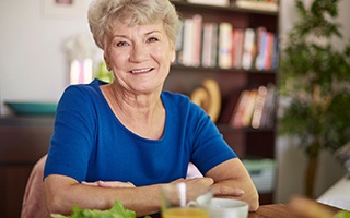 Senior woman sitting at table for meal