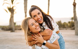 Two friends smiling together outside