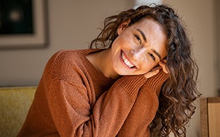 Woman in brown sweater smiling