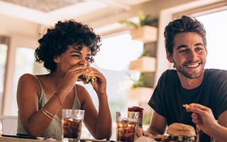 Smiling friends eating lunch in restaurant