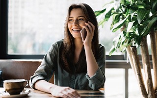 Smiling woman talking on phone at home