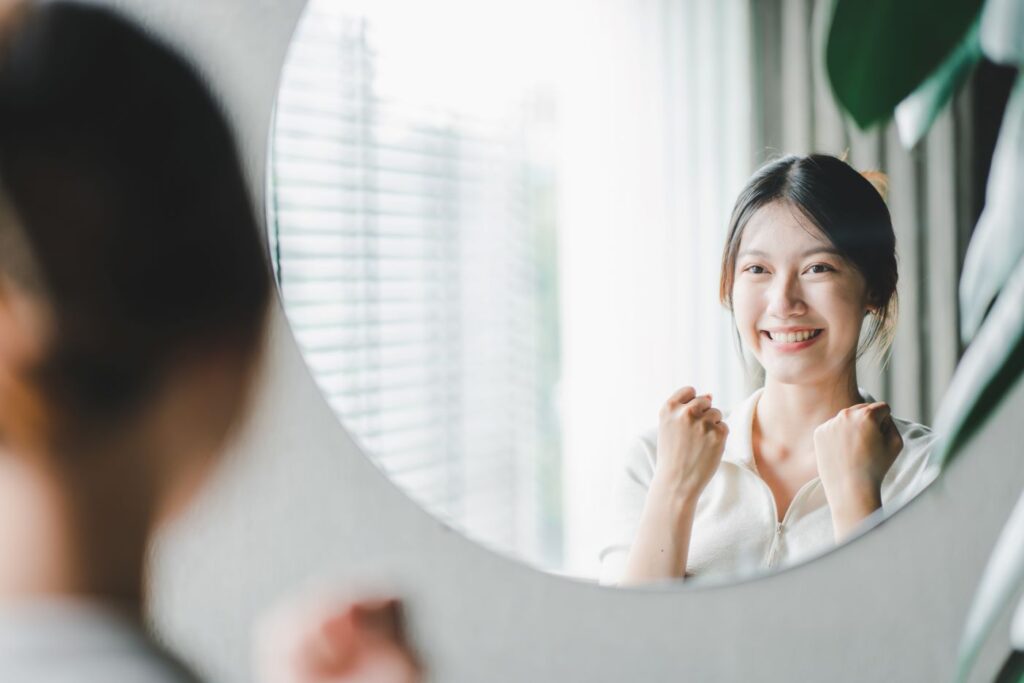 A woman smiling in a mirror.